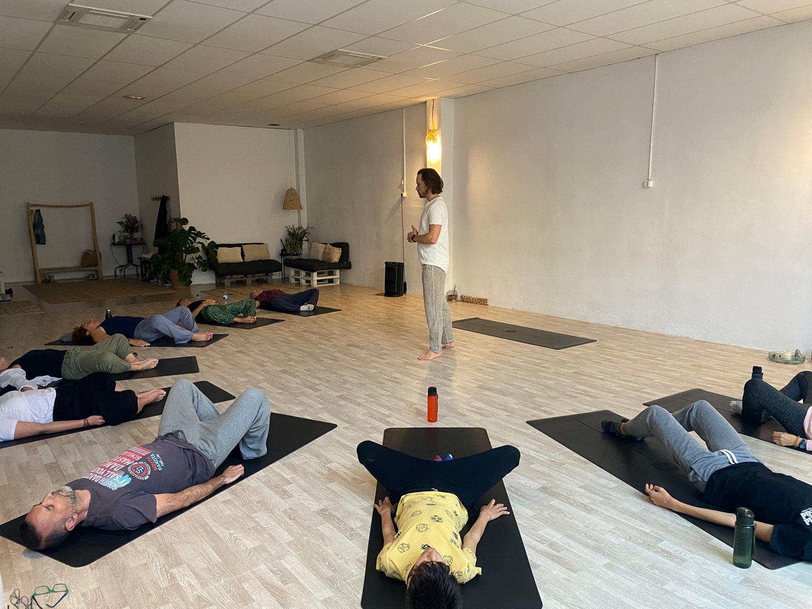 A guided TRE workshop with participants resting on exercise mats